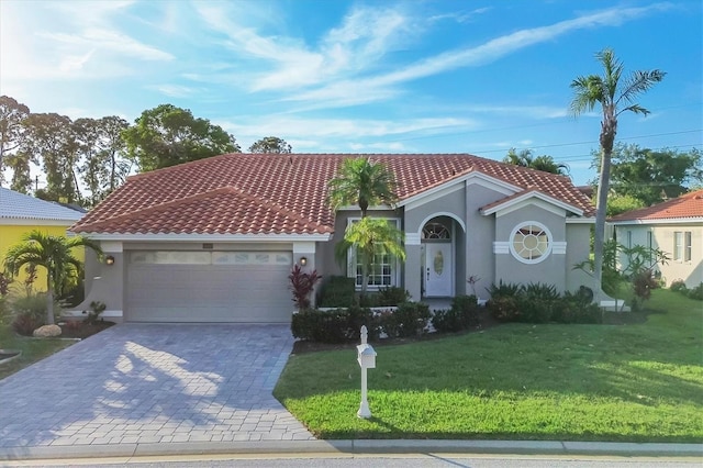 mediterranean / spanish-style home featuring a front lawn and a garage