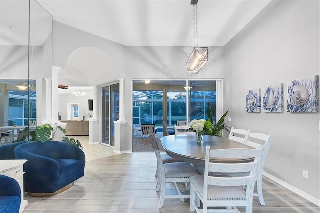 dining space featuring a towering ceiling and hardwood / wood-style flooring