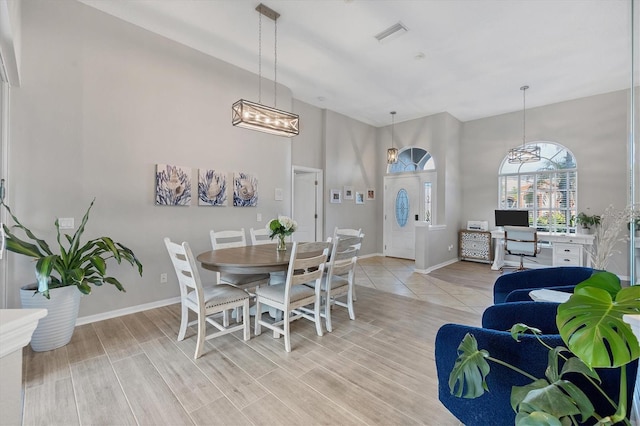 dining space with a notable chandelier and light hardwood / wood-style floors