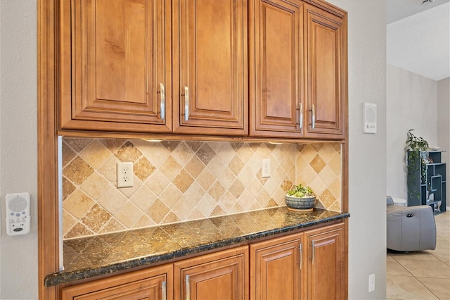 kitchen featuring dark stone counters, tasteful backsplash, and light tile floors