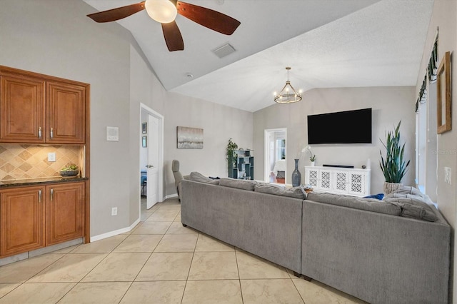 living room featuring lofted ceiling, light tile floors, and ceiling fan with notable chandelier