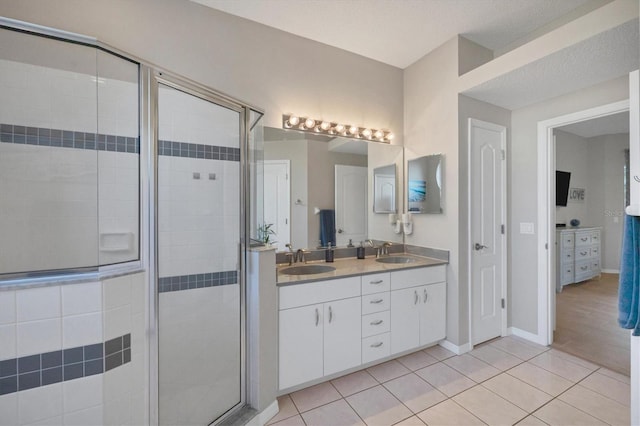 bathroom with a shower with shower door, hardwood / wood-style floors, and double vanity