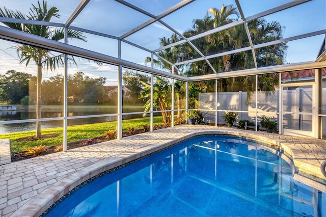 view of pool with a lanai, a water view, and a patio