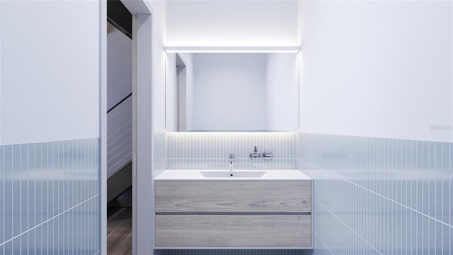 bathroom featuring vanity, wood-type flooring, and tile walls