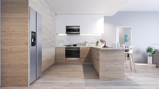 kitchen with stainless steel appliances, backsplash, kitchen peninsula, white cabinets, and light wood-type flooring