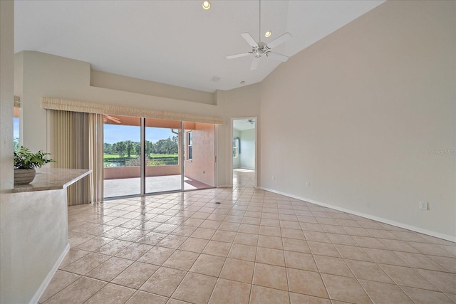 tiled empty room with a water view, high vaulted ceiling, and ceiling fan