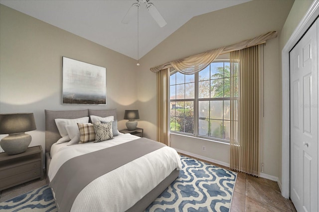 bedroom with a closet, vaulted ceiling, ceiling fan, and light tile patterned flooring