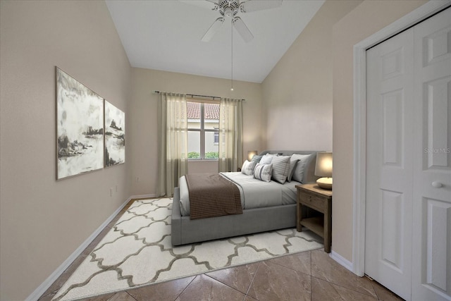 bedroom featuring ceiling fan, a closet, light tile patterned flooring, and vaulted ceiling