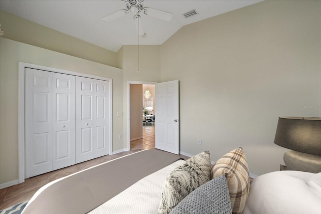 tiled bedroom featuring ceiling fan, a closet, and vaulted ceiling