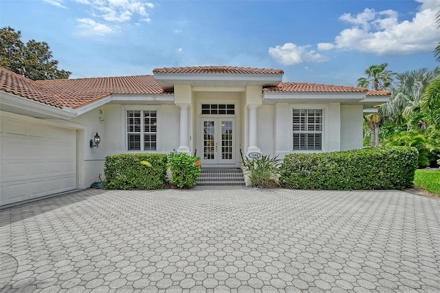 mediterranean / spanish house featuring a garage and french doors