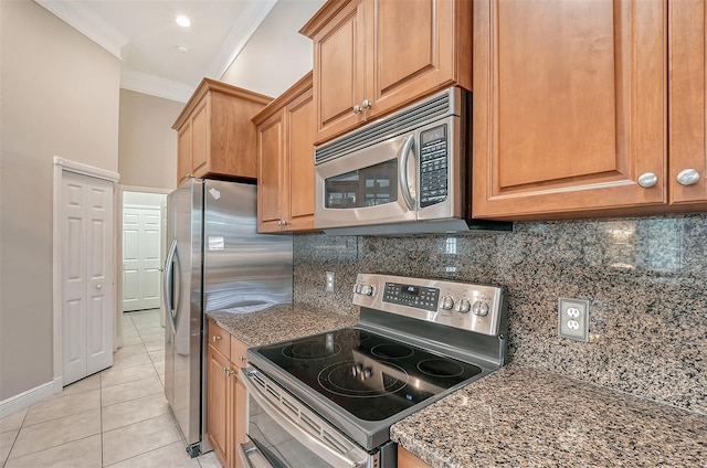 kitchen featuring dark stone counters, crown molding, backsplash, light tile floors, and appliances with stainless steel finishes