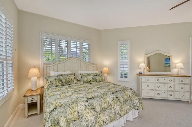 carpeted bedroom with multiple windows and ceiling fan