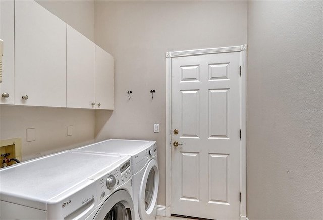 washroom with hookup for a washing machine, washer and clothes dryer, and cabinets