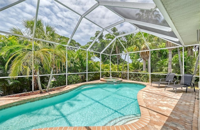 view of pool featuring a lanai, an in ground hot tub, and a patio area