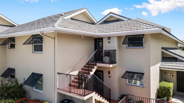 view of front of home featuring a balcony and central AC unit