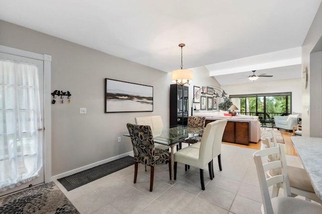 dining space with ceiling fan with notable chandelier, light tile patterned flooring, and lofted ceiling