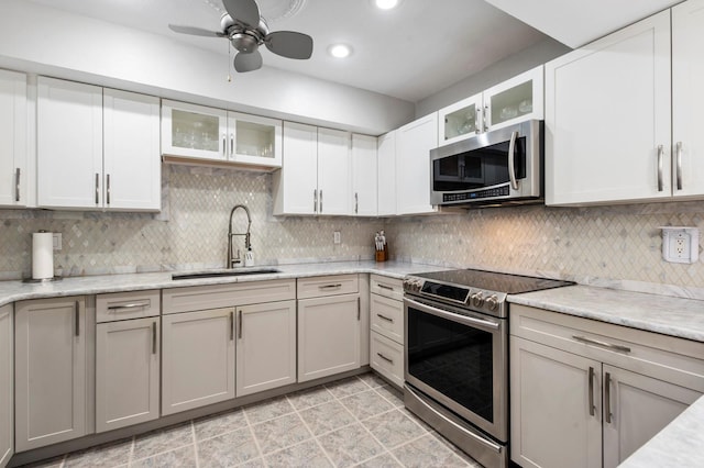 kitchen featuring appliances with stainless steel finishes, tasteful backsplash, ceiling fan, sink, and white cabinets