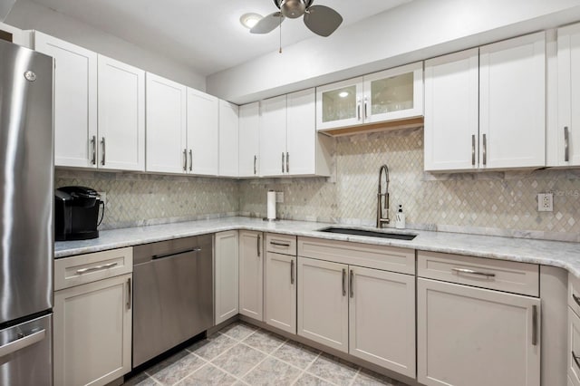 kitchen featuring decorative backsplash, appliances with stainless steel finishes, white cabinets, and sink