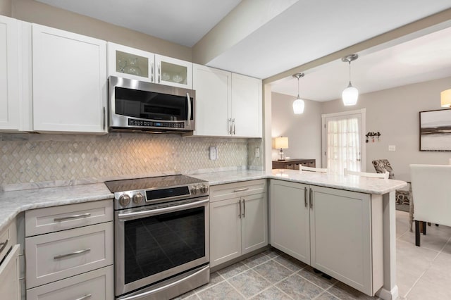 kitchen featuring kitchen peninsula, tasteful backsplash, light stone counters, stainless steel appliances, and pendant lighting