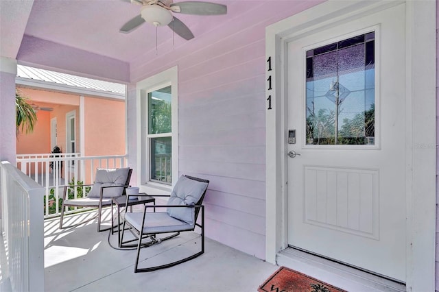 entrance to property featuring a porch and ceiling fan