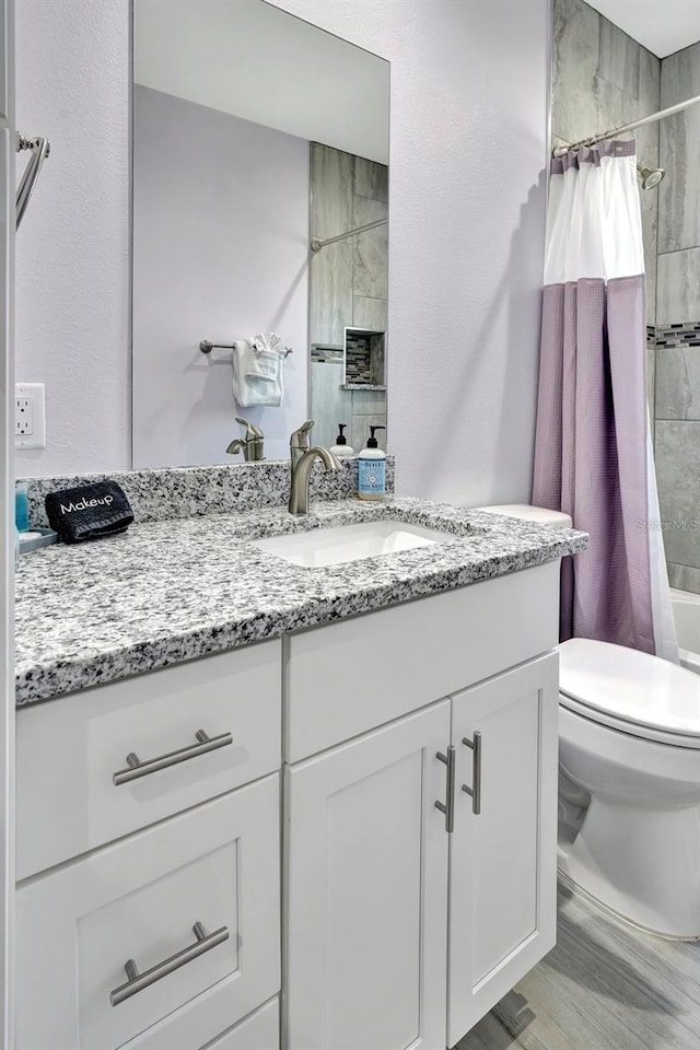 full bathroom with shower / bathtub combination with curtain, toilet, and large vanity