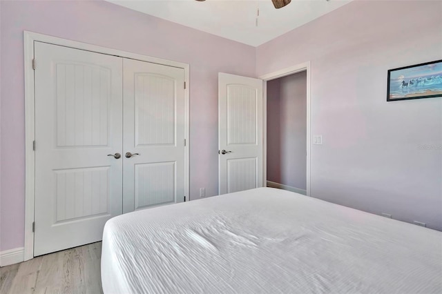 bedroom with a closet, ceiling fan, and light hardwood / wood-style flooring