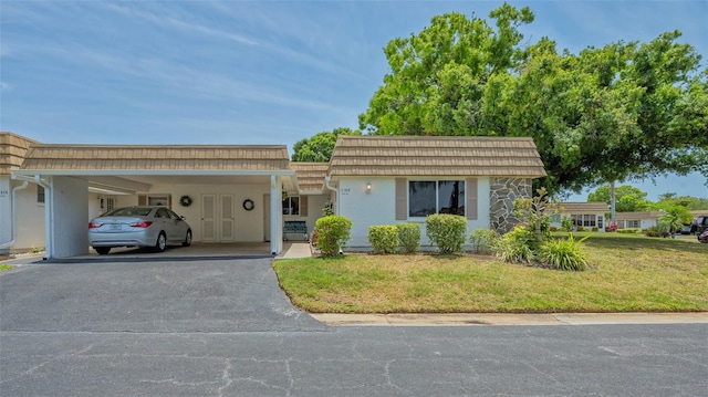 single story home featuring a front yard and a carport