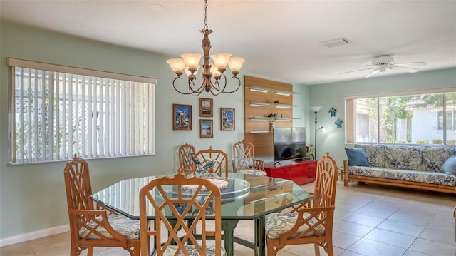 tiled dining room with ceiling fan with notable chandelier