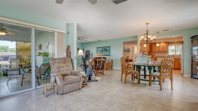 tiled dining area with ceiling fan with notable chandelier