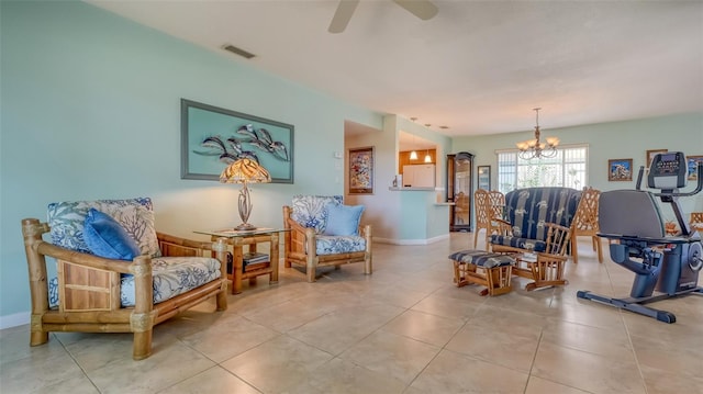 living area featuring tile flooring and ceiling fan with notable chandelier