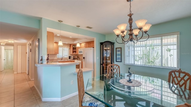 dining space with a notable chandelier, sink, and light tile floors