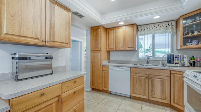 kitchen featuring a tray ceiling, white appliances, light tile floors, sink, and ornamental molding