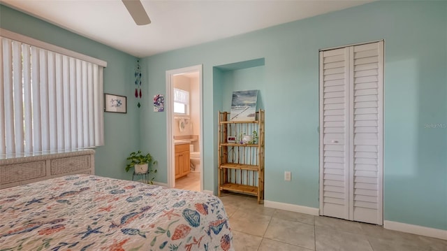 tiled bedroom featuring ceiling fan, a closet, and ensuite bathroom