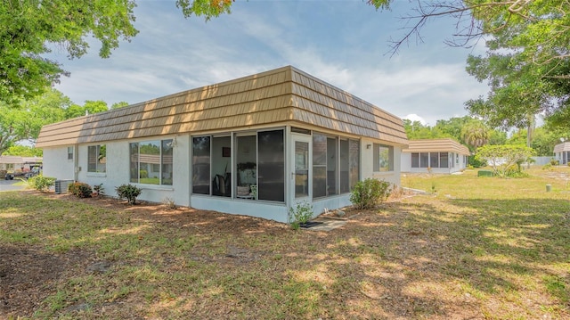 rear view of property with a sunroom and a yard