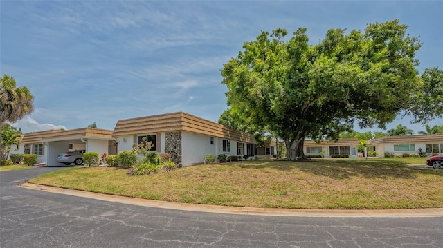 view of front of home with a garage and a front lawn