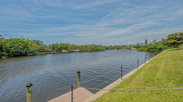 view of dock with a yard and a water view