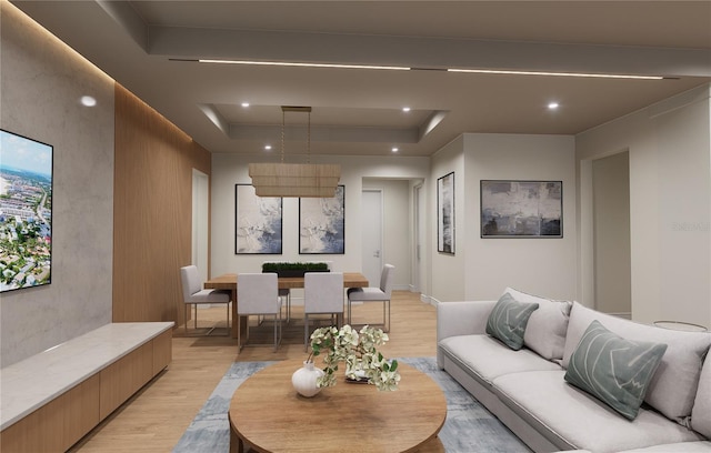 living room featuring a tray ceiling and light hardwood / wood-style flooring