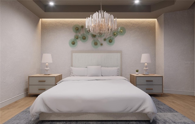 bedroom featuring a chandelier, light hardwood / wood-style floors, and a raised ceiling