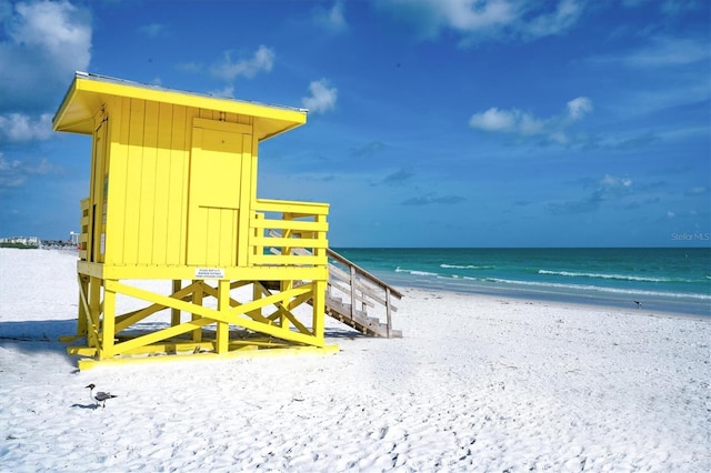 view of property's community with a water view and a beach view