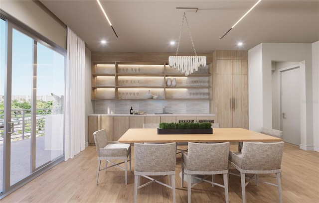 dining space with sink, a chandelier, and light wood-type flooring