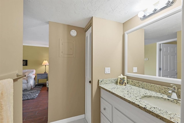 bathroom with a textured ceiling, vanity, and hardwood / wood-style flooring