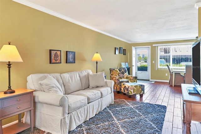 living room with ornamental molding, baseboards, and wood finished floors