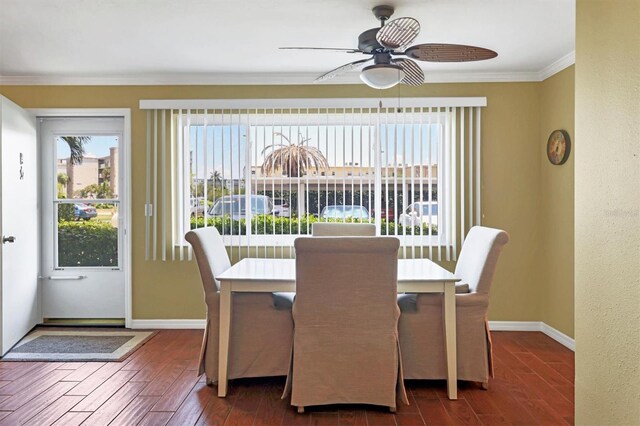 dining space featuring baseboards, crown molding, wood finished floors, and a ceiling fan