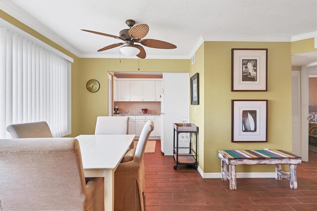 dining area with crown molding, dark wood-style flooring, baseboards, visible vents, and a ceiling fan