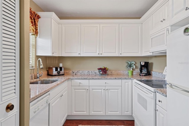 kitchen featuring white cabinetry, a sink, light stone countertops, and white appliances