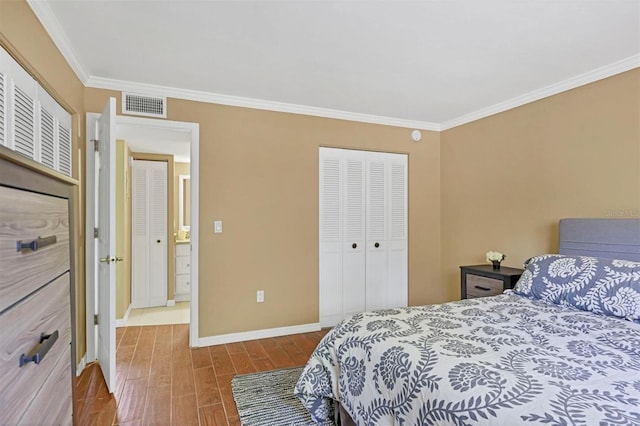 bedroom with a closet, visible vents, baseboards, ornamental molding, and wood finished floors