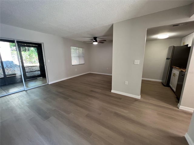 spare room featuring dark hardwood / wood-style floors, ceiling fan, and a textured ceiling