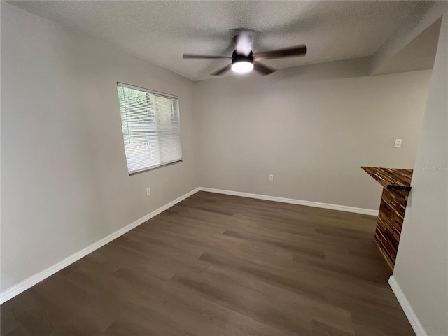 interior space with a textured ceiling, dark hardwood / wood-style floors, and ceiling fan