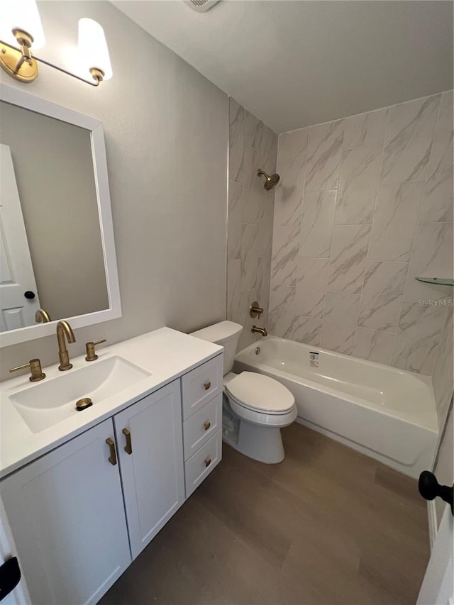 full bathroom with tiled shower / bath combo, wood-type flooring, vanity, and toilet