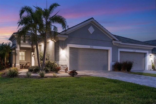 ranch-style home featuring a lawn and a garage